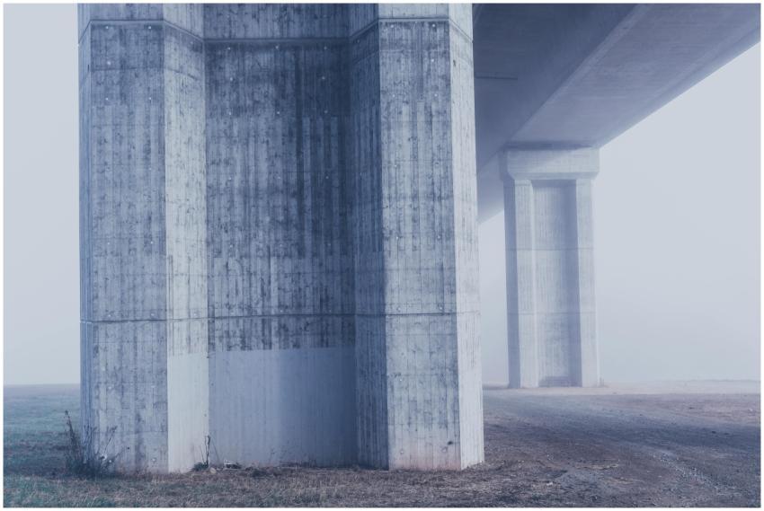 Misty view of concrete bridge columns in a foggy u