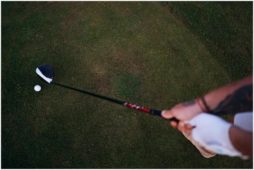 Golfer preparing to swing on a lush course, showin