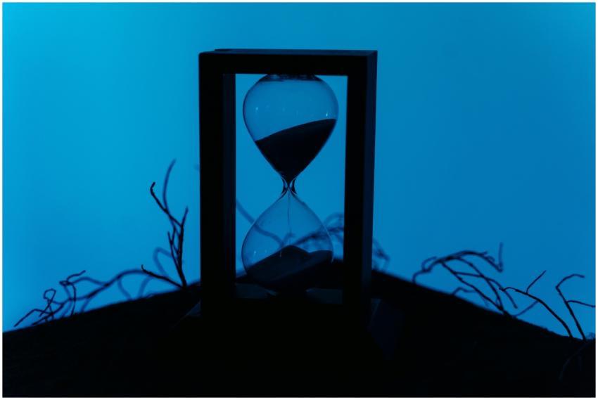 A silhouette of an hourglass set against a vivid b