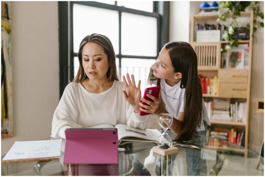 A mother and daughter interact with technology whi