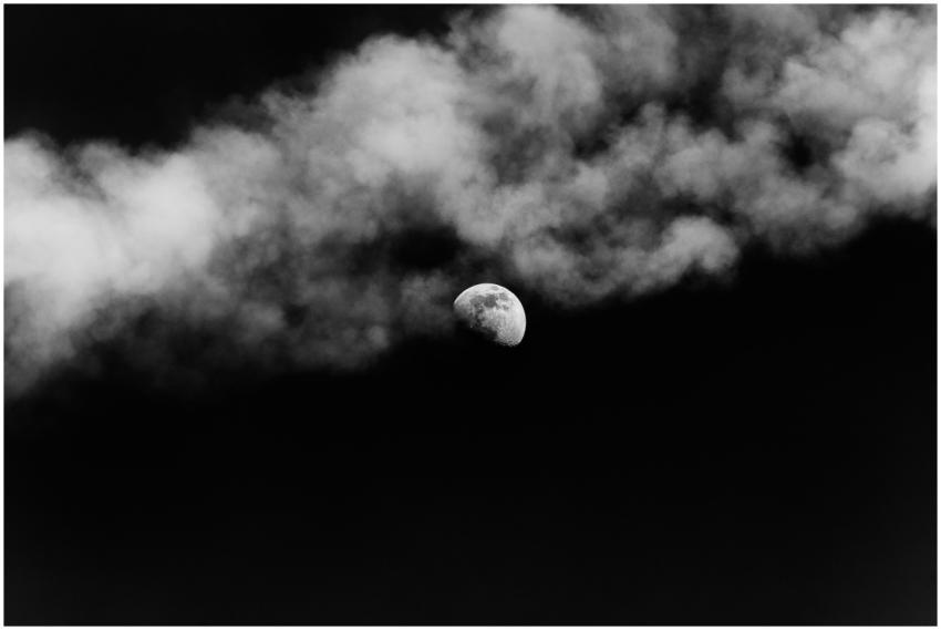Black and white of shining moon on dark gloomy sky
