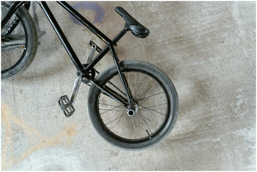 Black BMX bike viewed from above on a concrete sur