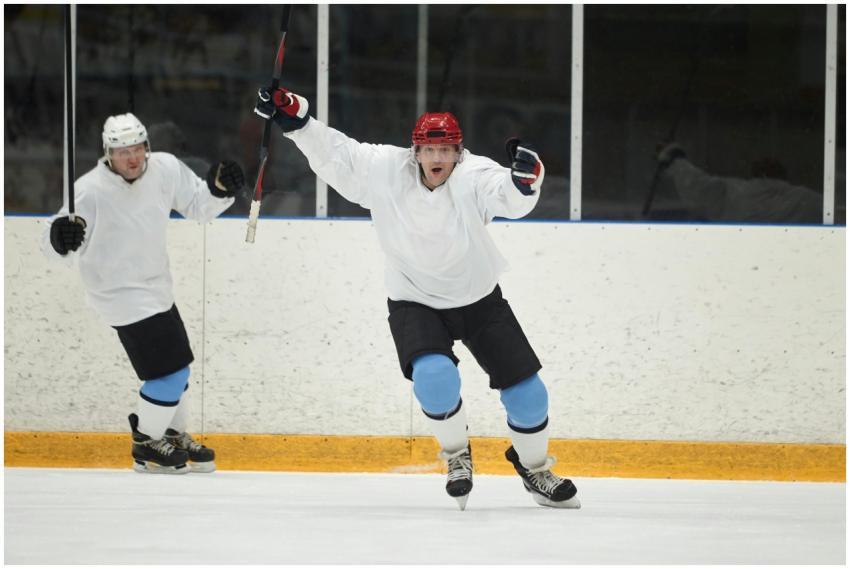 Two ice hockey players in white and blue uniforms
