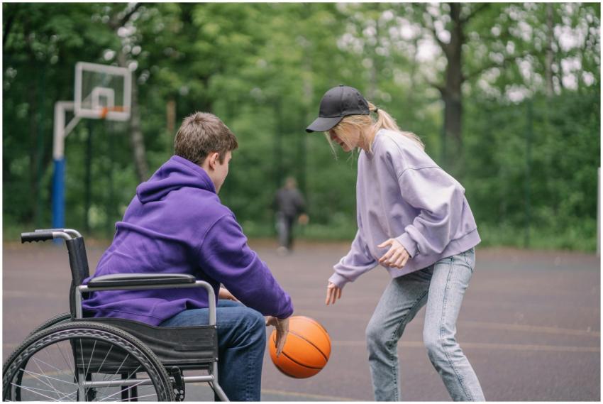 A man in wheelchair playing basketball with a woma