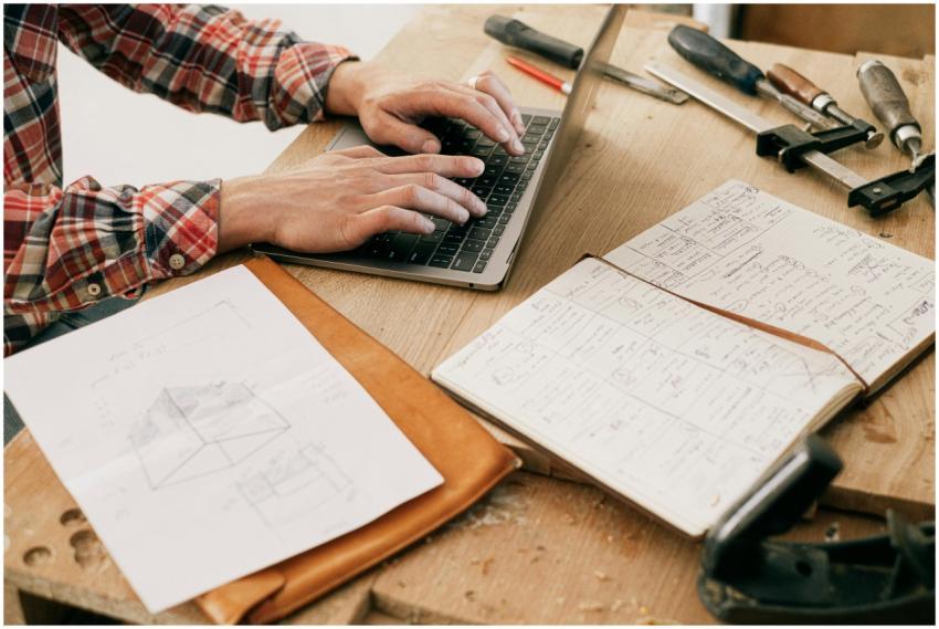 A woodworker uses a laptop to design furniture in