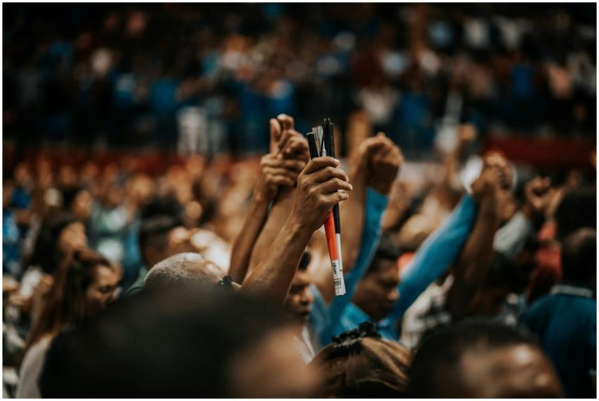 Energetic crowd with raised hands in a vibrant ind