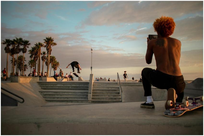 A skateboarder performs a trick at a vibrant skate