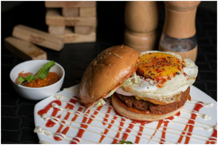 Tasty burger topped with a fried egg, garnished wi