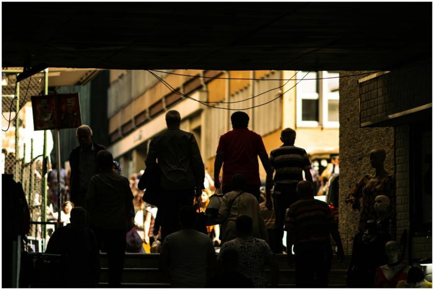Silhouetted people walking up stairs in an urban s