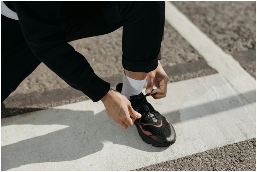 Close-up of a person tying their sneaker on an out
