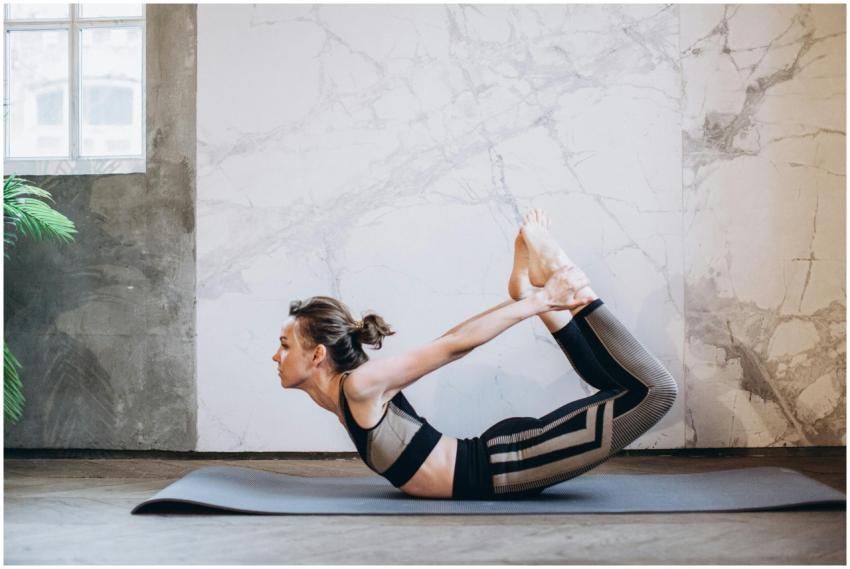 A woman performing the bow pose in a serene indoor