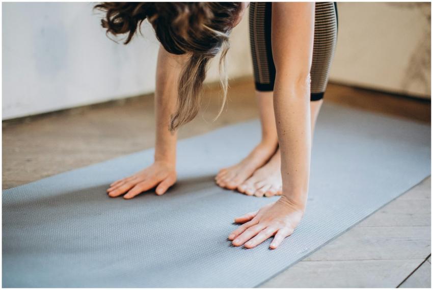An adult woman performing a forward bend yoga pose