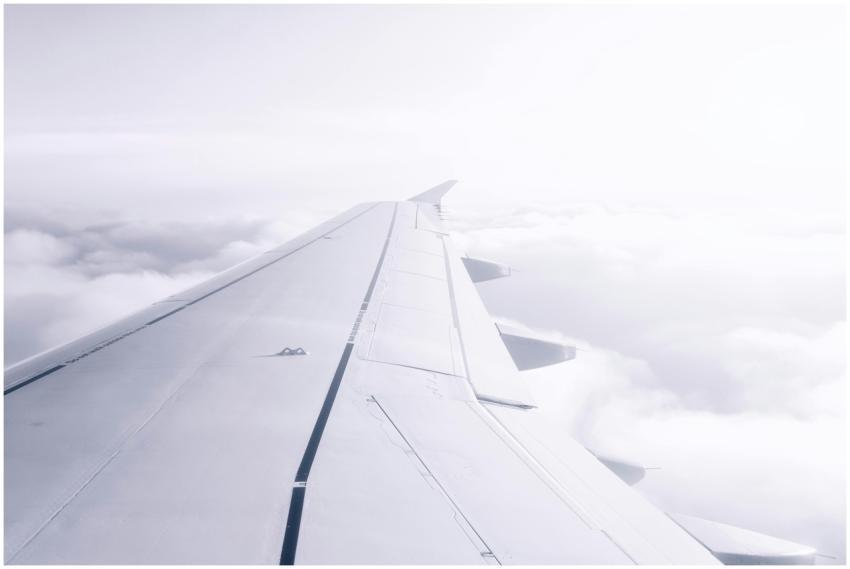A serene view of an airplane wing flying above the