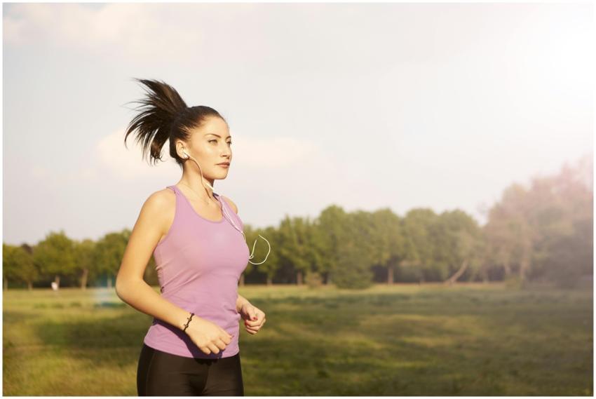 Female jogger running outdoors in a purple tank to