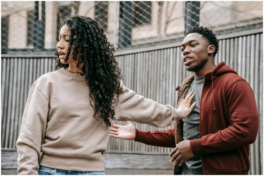 A couple in casual clothing appears to be in a dis