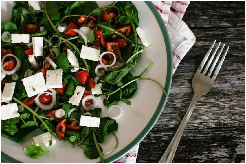 A vibrant and colorful spinach salad with feta che