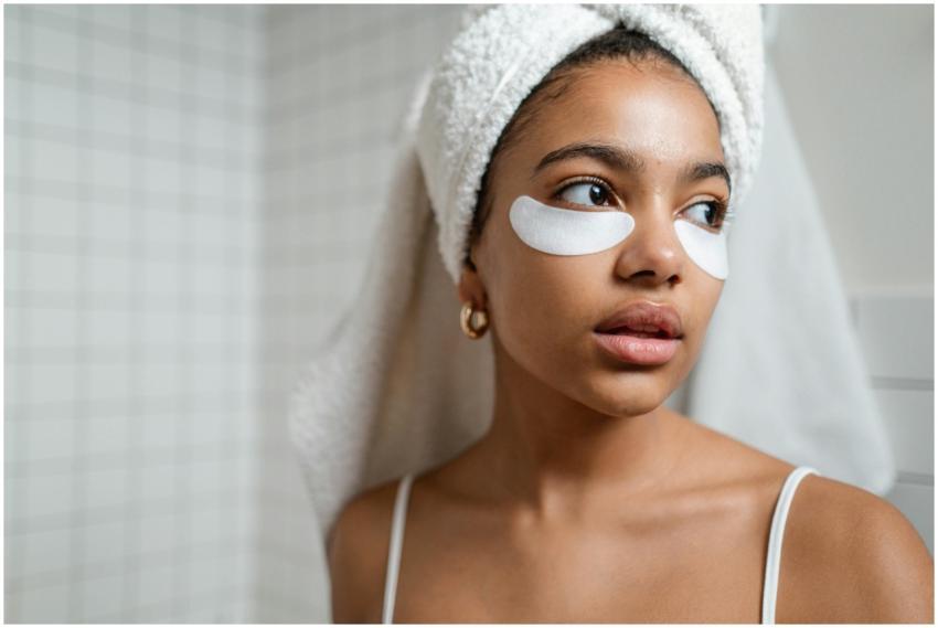A young woman with a towel on her head applying un