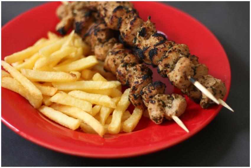 A vibrant meal of grilled chicken skewers and cris