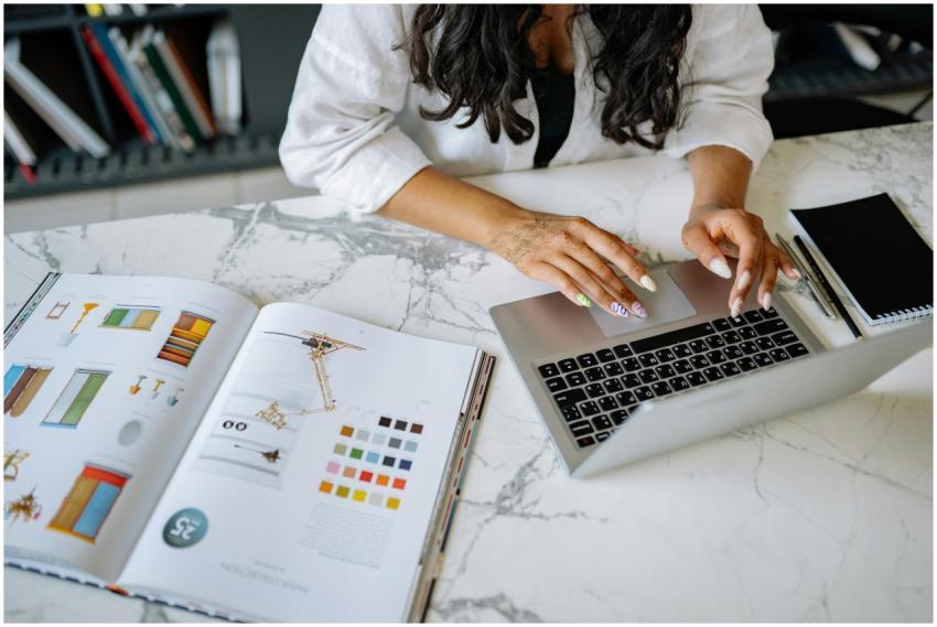 A woman works on a laptop at a marble desk with a