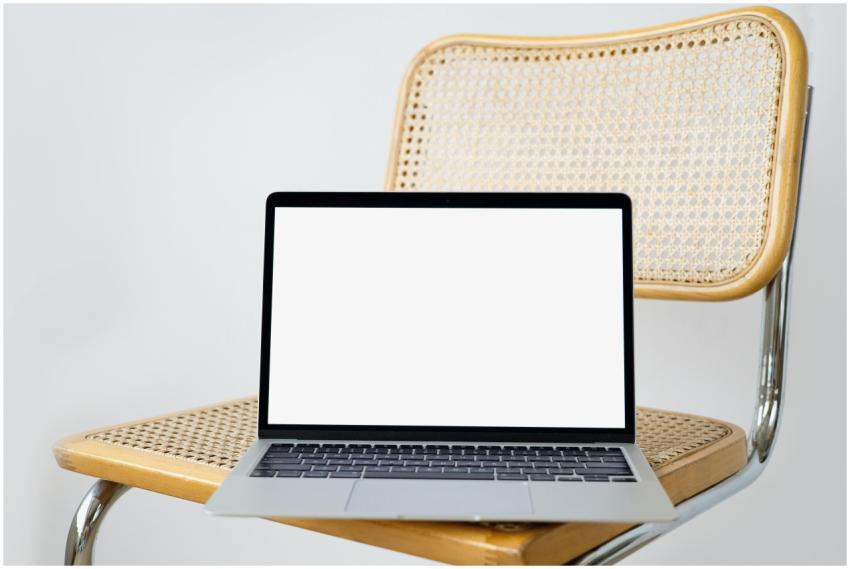 Modern laptop with a blank screen on a woven chair