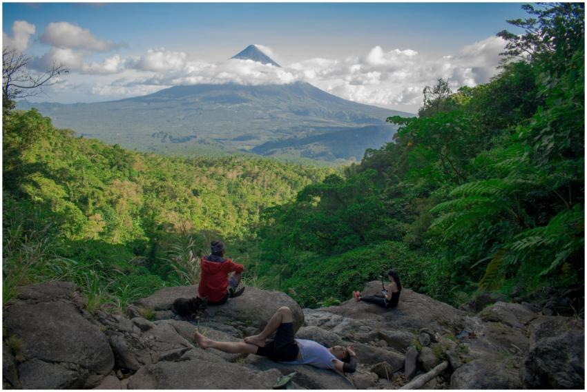 Hikers rest with a scenic view of Mayon Volcano in