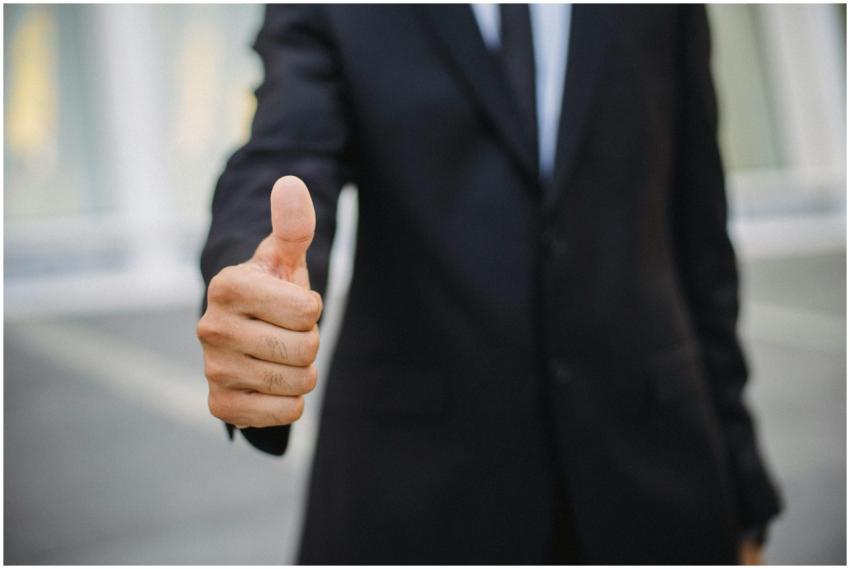 Close-up of a businessman in a suit giving a thumb