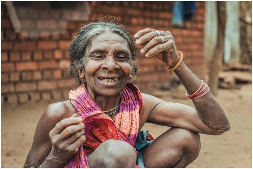 Elderly Indian woman smiling outdoors, embracing c