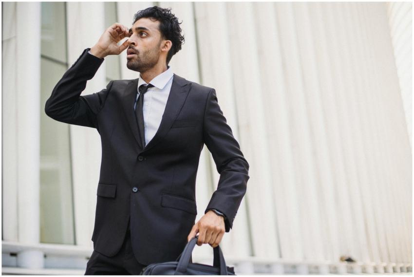 A young businessman in a suit, holding a briefcase