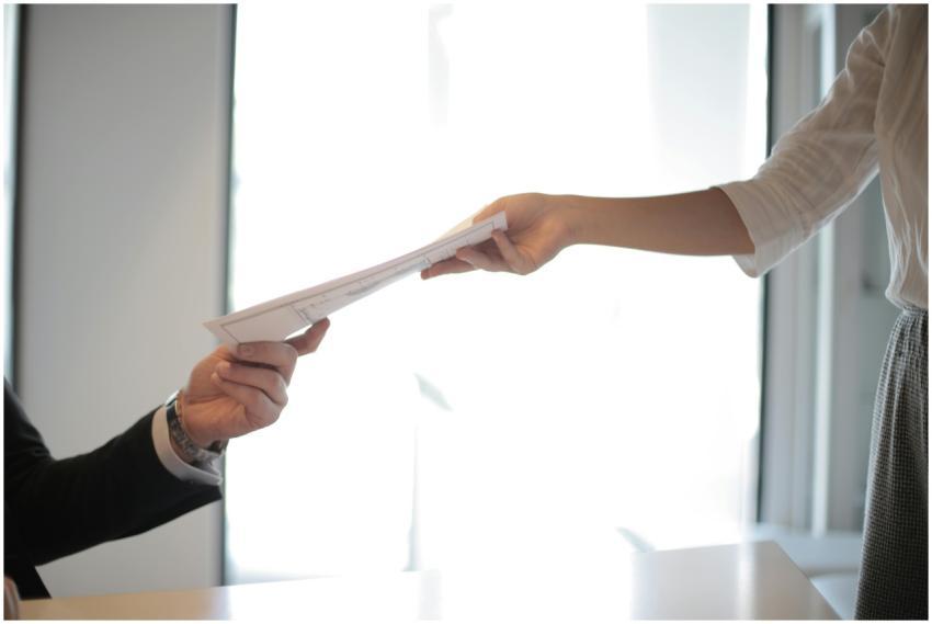 Close-up of hands exchanging documents in a busine