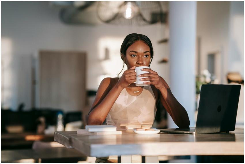 A stylish woman drinking coffee and working on a l