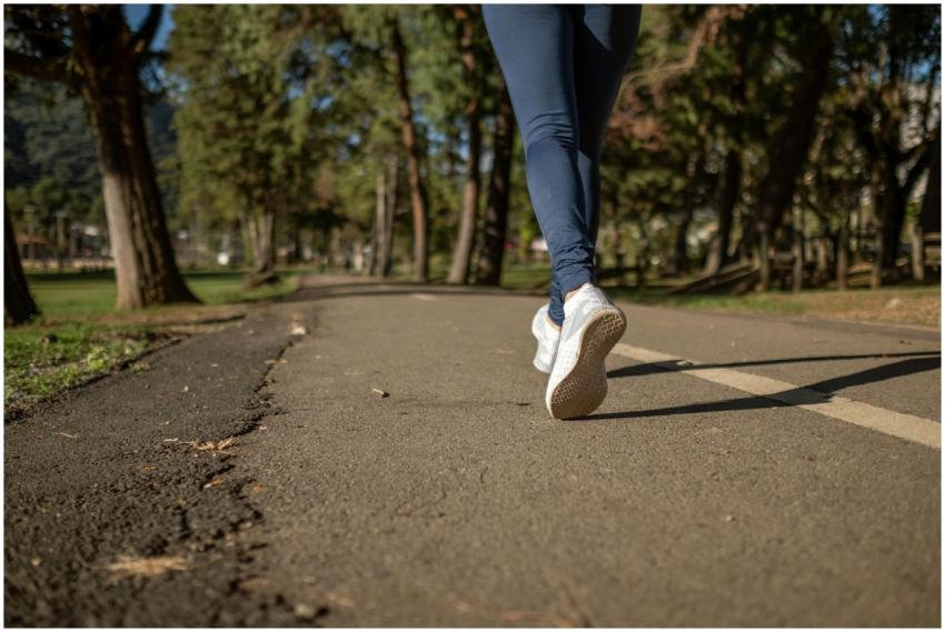 A woman jogging on a path through a park, showcasi