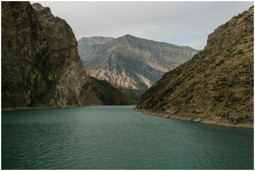 A tranquil lake nestled between towering rocky mou