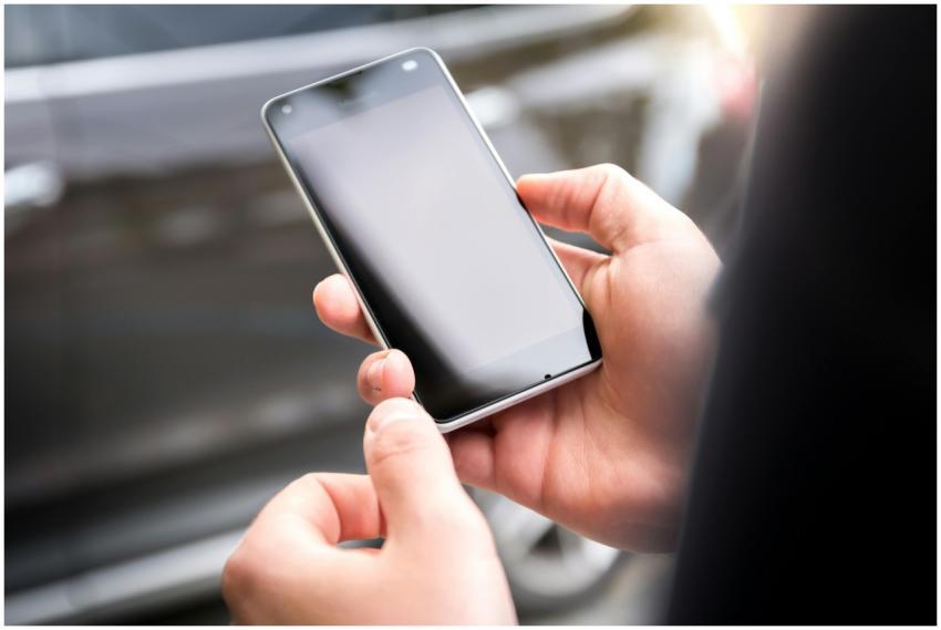 Close-up of hands holding a smartphone outdoors du