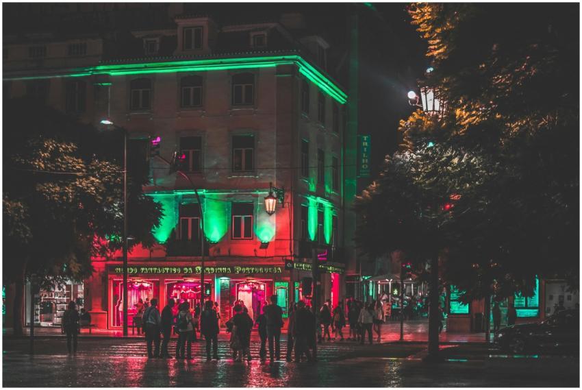 A lively urban street scene at night featuring neo