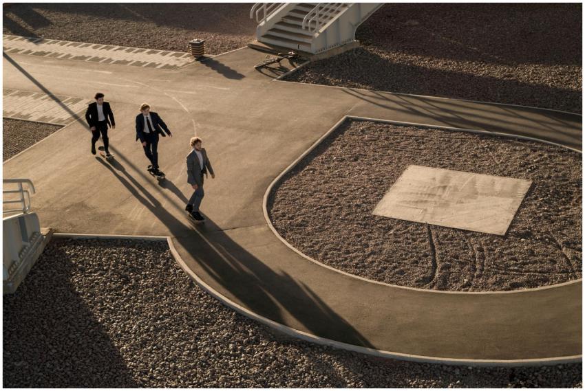 Aerial view of three businessmen in suits skateboa