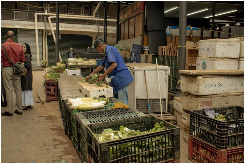 A lively indoor market with people and fresh veget