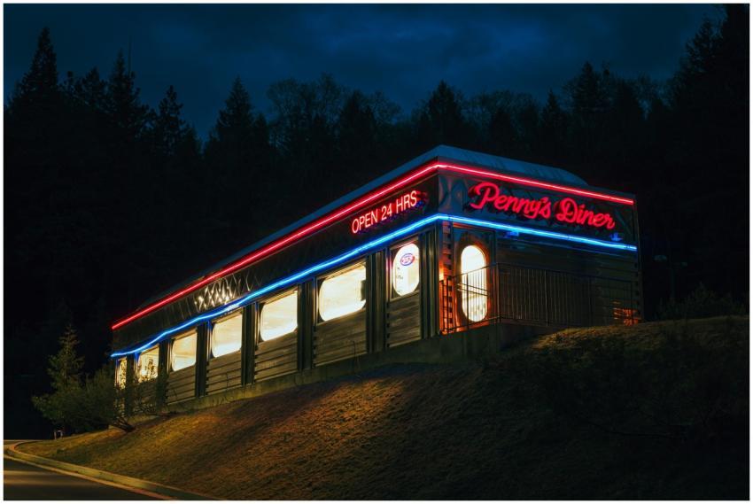 Diner exterior with vibrant neon lights at night,