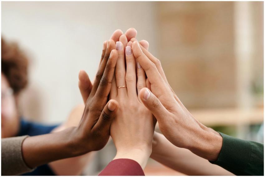 Close-up of diverse group hands high-fiving symbol