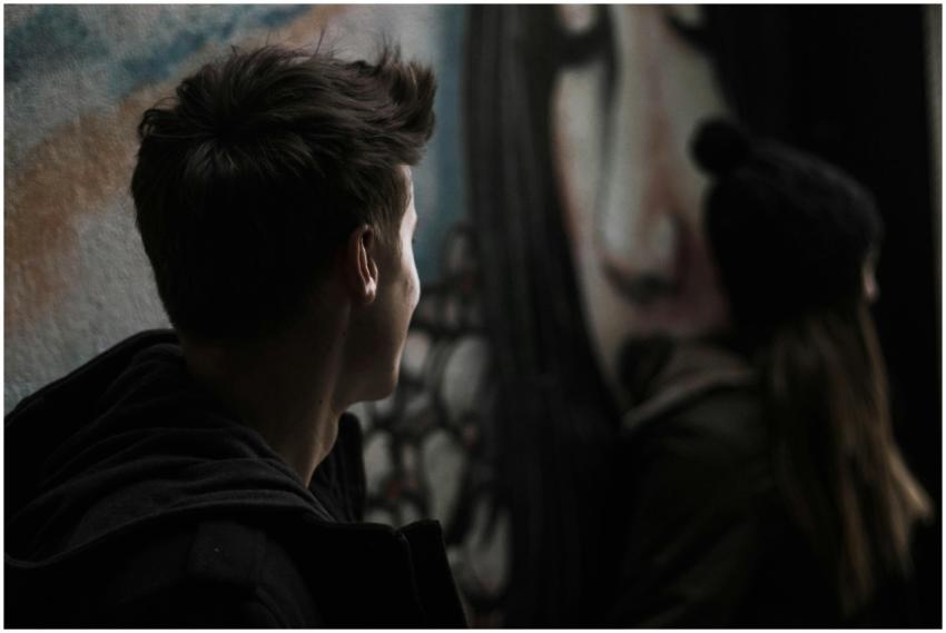 Young adults near urban street art. Moody and arti