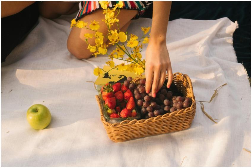 A vibrant picnic setup with strawberries, grapes,