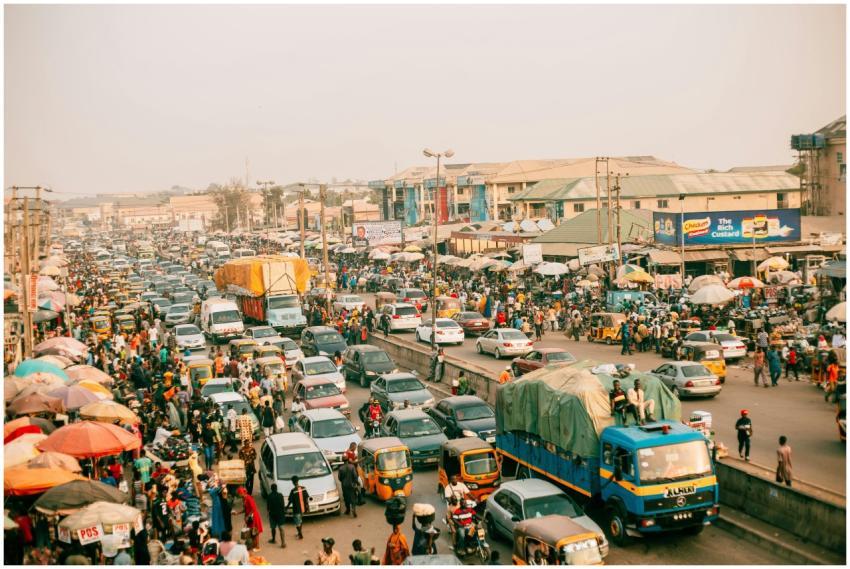 A busy street market scene with heavy traffic and