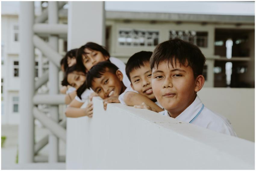 Group of children leaning on school corridor raili