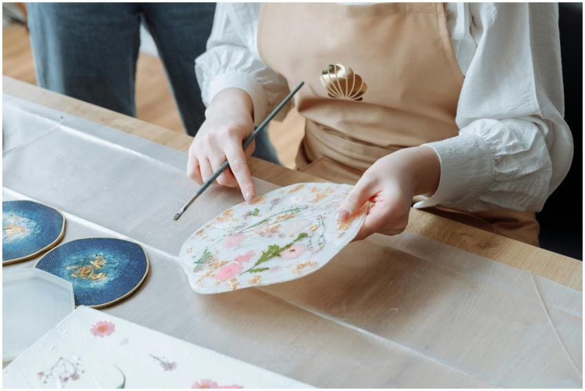 Close-up view of a person painting art pieces in a