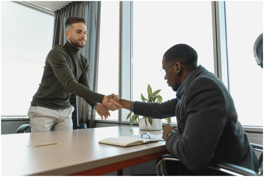 Two businessmen shaking hands in a modern office a