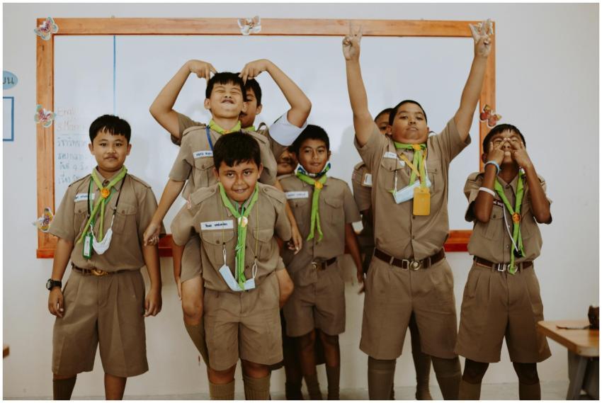 Playful school children in uniforms having fun dur