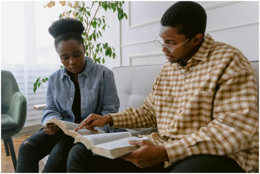 Two individuals engaged in reading the Bible toget