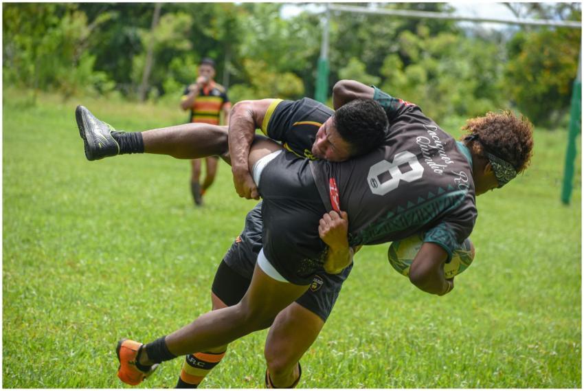 Rugby players in an action-packed tackle during a