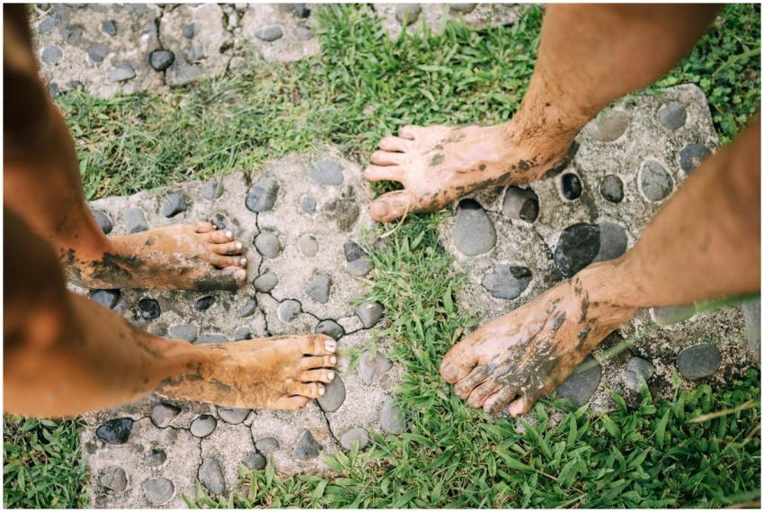 Two adults with muddy feet on a stone path enjoyin
