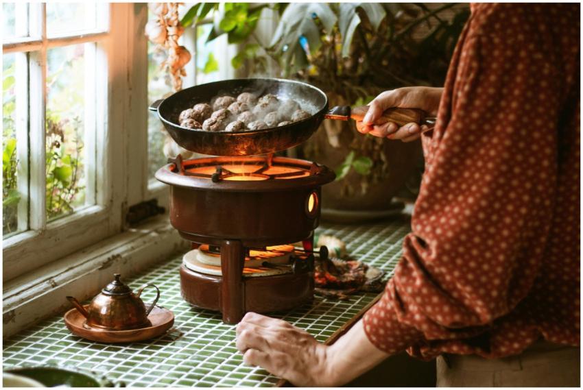 Warm kitchen setting with meatballs cooking over a