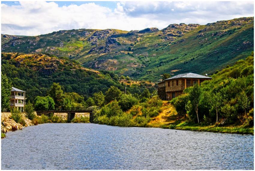 Picturesque view of a river and bridge with lush h